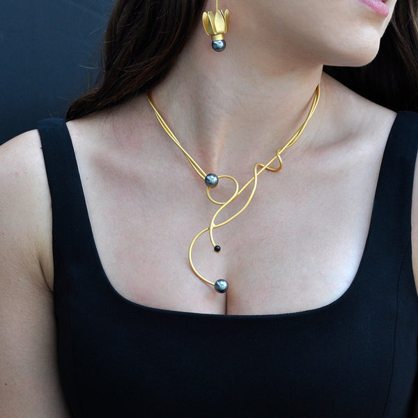 gold sculptural necklace with black pearl