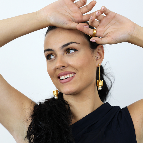 Gold tulip dangle earrings adorned with a white pearl